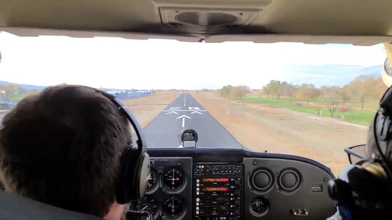 Student on short final to the runway with an instructor beside him
